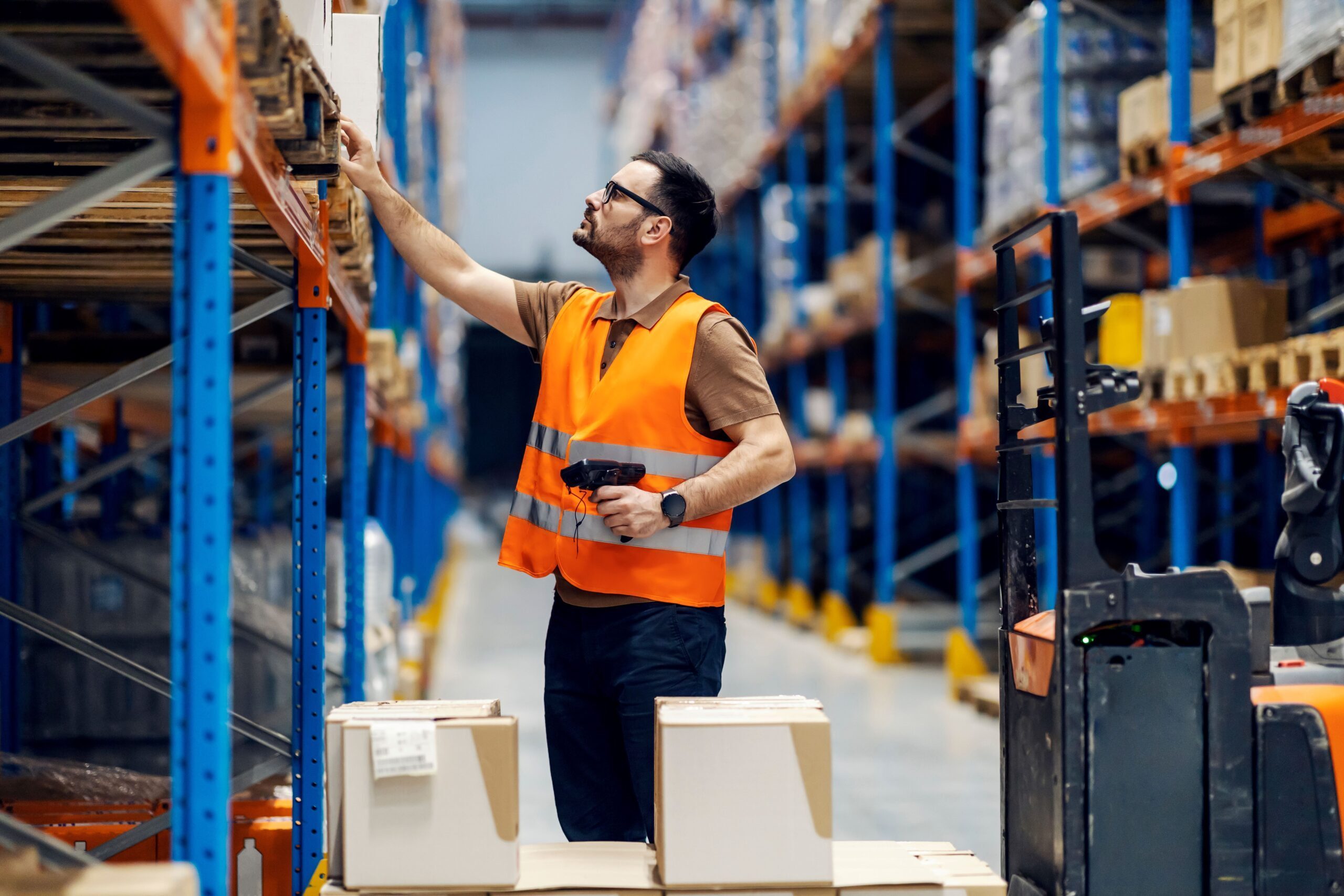 Man in warehouse using RFID reader for inventory tracking